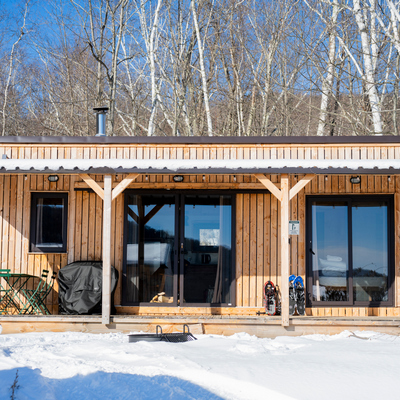 Tiny wooden cabin in winter with fire pit